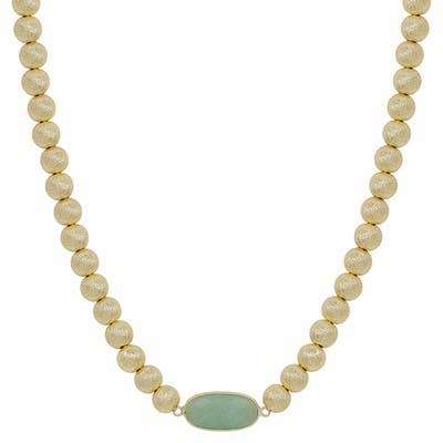 Beaded necklace with a green pendant on a white background