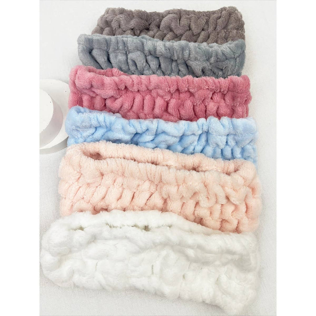 Stack of colorful textured headbands on a white background