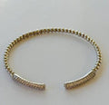 Gold bracelet on a light gray background