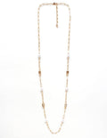 Gold chain necklace with small pearls on a white background