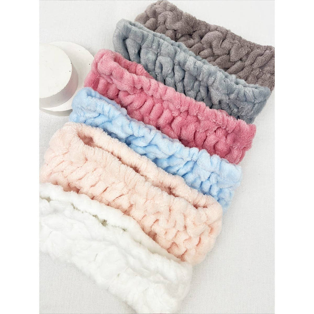 Set of five knitted headbands in various colors on a white background