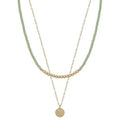 Two layered necklaces with green and beige beads on a white background