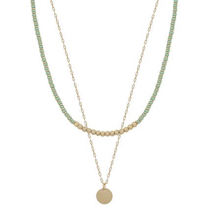 Two layered necklaces with green and beige beads on a white background