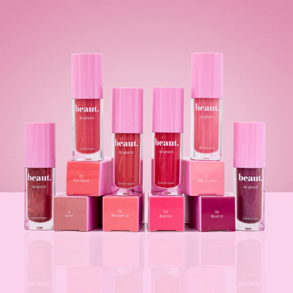 Set of pink lip gloss bottles with visible brand name on a pink background