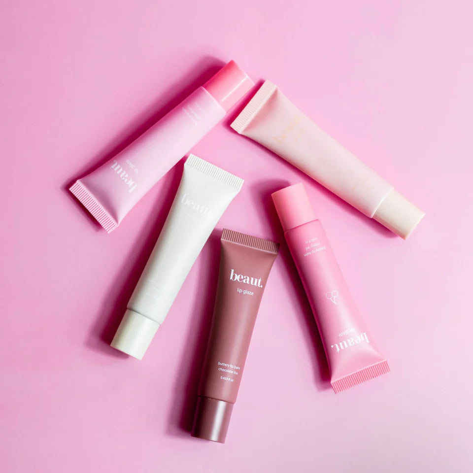 Set of pink and white skincare tubes on a pink background