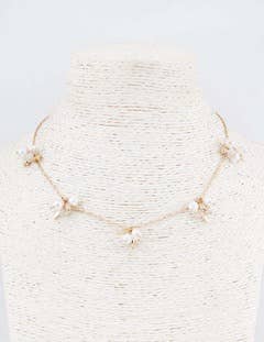 Delicate necklace on a mannequin with a light gray background